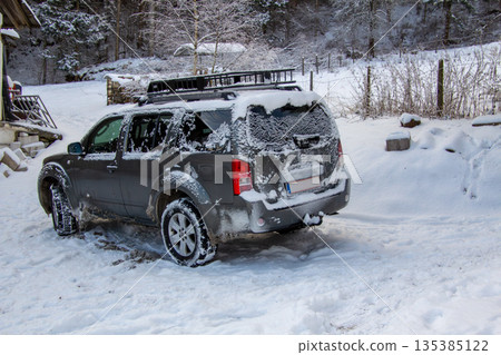 Four-wheel drive car covered with snow and ice 135385122