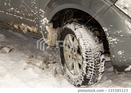 Road salt of the wheel of a snow covered car 135385123