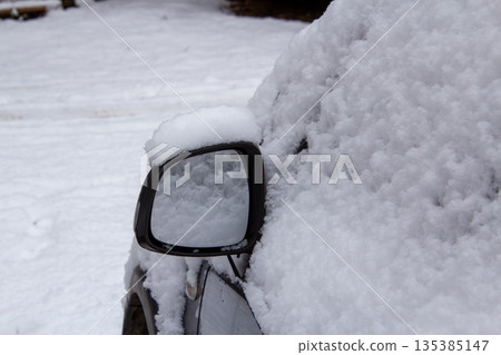Mirror of a four-wheel drive car covered with snow 135385147