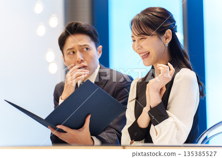 一位男士正為餐廳菜單而焦慮。 一位男士正為餐廳菜單而焦慮。 135385527