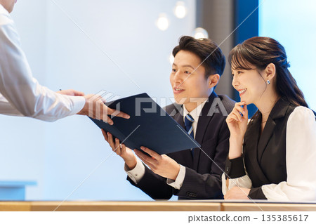 A couple receiving an explanation of the menu at a restaurant A couple receiving an explanation of the menu at a restaurant 135385617