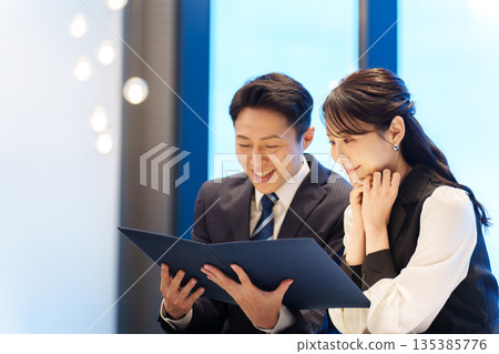 Couple looking at a menu at a restaurant 135385776