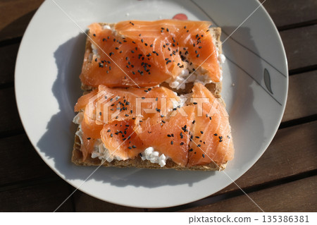 Gourmet salmon dish featuring smoked or raw cuts with toast or rice. Gourmet salmon dish featuring smoked or raw cuts with toast or rice. 135386381