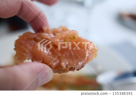 Gourmet salmon dish featuring smoked or raw cuts with toast or rice. Gourmet salmon dish featuring smoked or raw cuts with toast or rice. 135386391