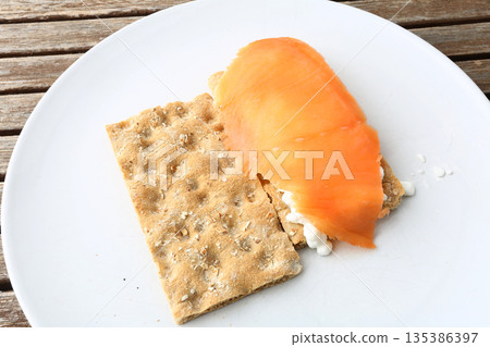 Gourmet salmon dish featuring smoked or raw cuts with toast or rice. 135386397