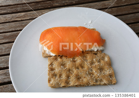 Gourmet salmon dish featuring smoked or raw cuts with toast or rice. Gourmet salmon dish featuring smoked or raw cuts with toast or rice. 135386401