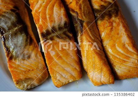 Gourmet salmon dish featuring smoked or raw cuts with toast or rice. Gourmet salmon dish featuring smoked or raw cuts with toast or rice. 135386402