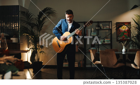 Man Playing a guitar in a club Man Playing a guitar in a club 135387028