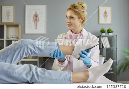 Podiatrist examining patient foot mobility and fitting orthopedic inserts Podiatrist examining patient foot mobility and fitting orthopedic inserts 135387718