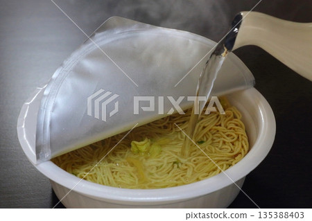 將熱水倒入炒麵杯中 將熱水倒入炒麵杯中 135388403