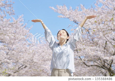 A woman taking a deep breath in front of cherry blossoms A woman taking a deep breath in front of cherry blossoms 135388486