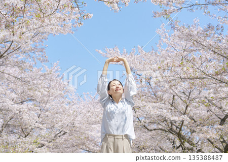A woman stretching in front of cherry blossoms A woman stretching in front of cherry blossoms 135388487