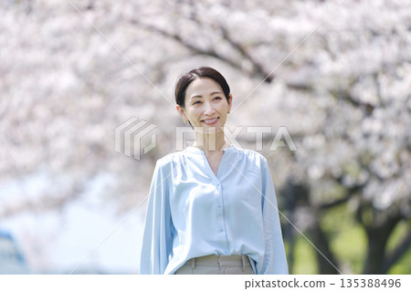 與盛開的櫻花一起散步的女人 135388496