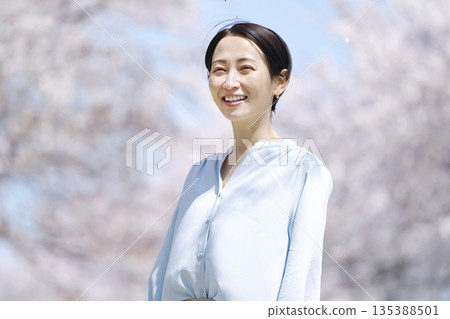 A woman taking a walk with the cherry blossoms in full bloom A woman taking a walk with the cherry blossoms in full bloom 135388501