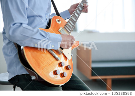 彈吉他的一個人的手 135388598