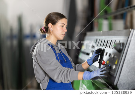 Girl workshop employee switches toggle switch on control panel Girl workshop employee switches toggle switch on control panel 135388929
