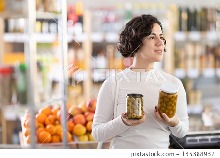 Adult woman choosing olives in grocery store 135388932