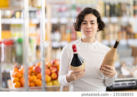 Adult woman choosing wine in grocery store 135388935