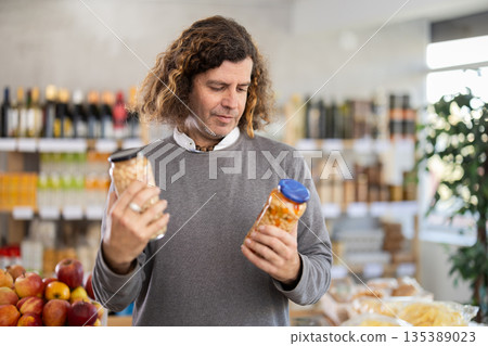 Man choosing cans of beans 135389023