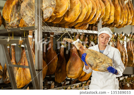 Girl checks quality of spanish jamon in workshop Girl checks quality of spanish jamon in workshop 135389033