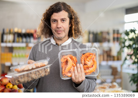 man chooses shrimp and shellfish 135389069