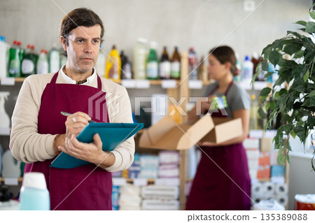 Owner of cleaning and hygiene products store recording inventory results 135389088