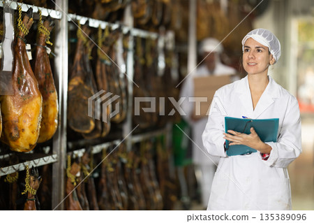 Female employee of the jamon factory conducts inventory and quality control 135389096
