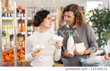 Husband and wife choose dairy products Husband and wife choose dairy products 135389314