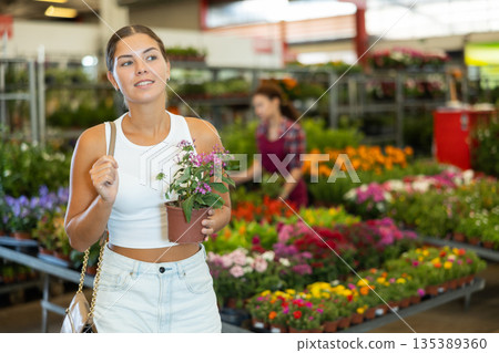 Young woman choosing pentas in pot Young woman choosing pentas in pot 135389360