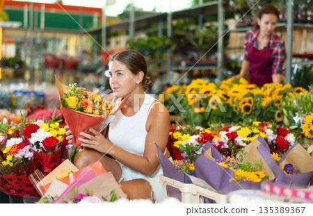 Young woman choosing bouquet of flowers Young woman choosing bouquet of flowers 135389367