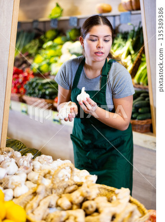 Young woman selling garlic in shop Young woman selling garlic in shop 135389386