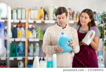 Female consultant helps man buyer choose liquid detergent Female consultant helps man buyer choose liquid detergent 135389443