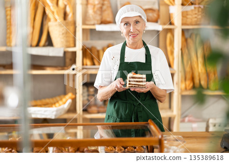 Elderly woman seller with piece of cake 135389618
