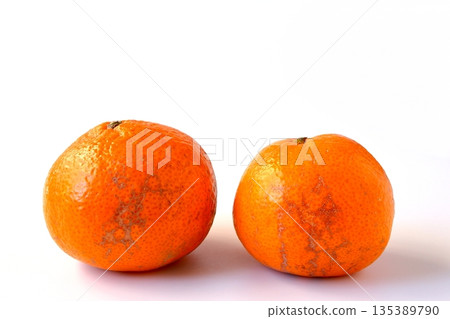 Damaged mandarin oranges on a white background 135389790