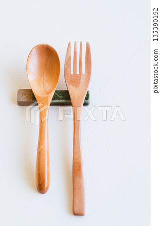 Wooden spoon and fork and cutlery rest on white background 135390192