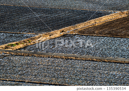 A landscape of rice fields covered in a thin layer of snow c-2 High saturation contrast 135390534