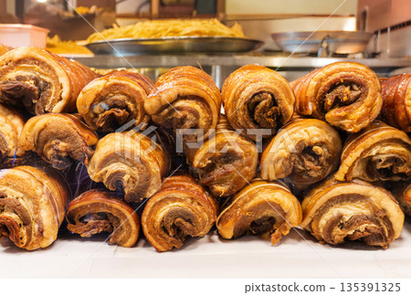 Close-up of crispy roasted pork belly rolls with golden brown crackling skin. Delicious Asian style street food and gourmet meat photography for restaurant marketing 135391325