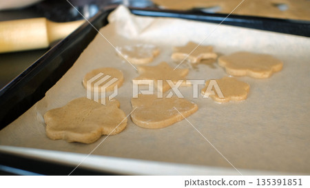Raw ginger cookie pieces on a parchment-lined baking tray, homemade baking and cooking Raw ginger cookie pieces on a parchment-lined baking tray, homemade baking and cooking 135391851