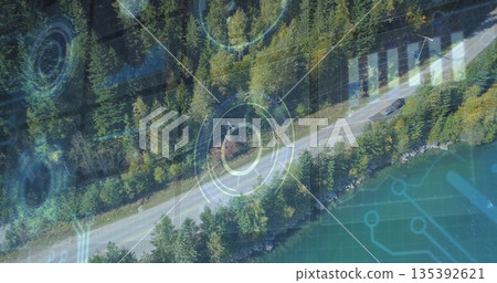 Traveling dark-colored car on two-lane road by turquoise lake among trees, with HUD overlays 135392621