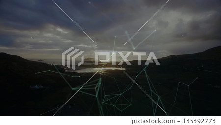 Displaying distant island reflecting on calm inlet water at dusk, with network lines and nodes 135392773