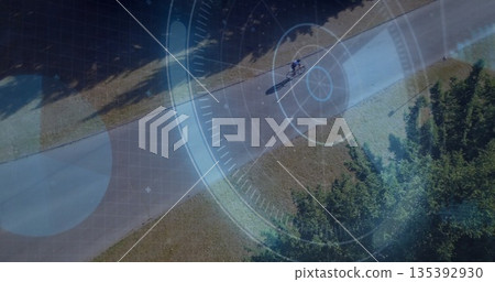 Riding teen cyclist wearing helmet, cycling shorts on bicycle through park, HUD overlay, copy space 135392930