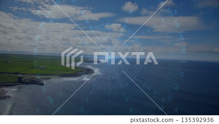 Displaying digital HUD compass gauge hovering above coastal cliffs meeting fields and ocean beyond 135392936