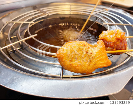 Deep-fried taiyaki (fish-shaped cake) on a skewer: A unique deep-fried sweet treat made by deep-frying taiyaki. Deep-fried taiyaki (fish-shaped cake) on a skewer: A unique deep-fried sweet treat made by deep-frying taiyaki. 135393229