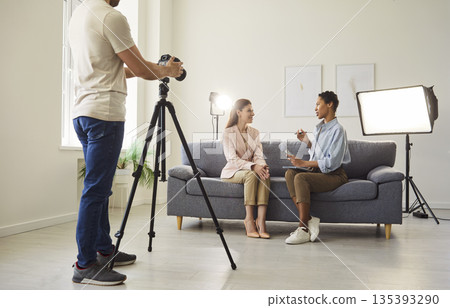 Video interview in modern living room with camera operator and two hosts Video interview in modern living room with camera operator and two hosts 135393290
