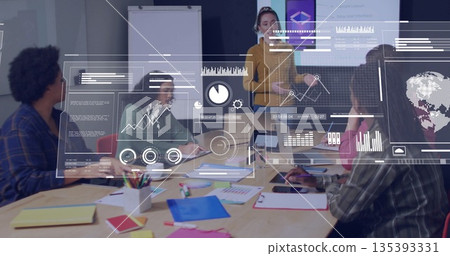 Presenting woman in mustard sweater explaining data in boardroom at table with laptops and overlays 135393331