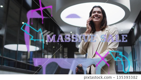 Smiling shopper talking on smartphone by mall railing, MASSIVE SALE doodle arrows, copy space 135393382