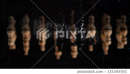 Suspending upside-down glossy black heeled boots in studio, with wooden pawns and digital overlay 135393501