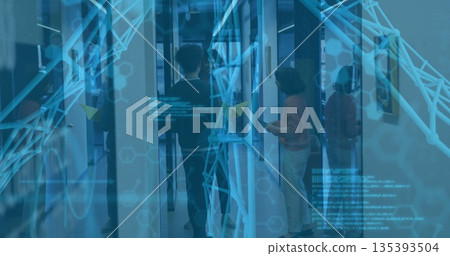 Collaborating three coworkers on digital screen in glass corridor, with cyan network graphics 135393504