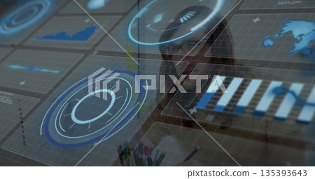 Man wearing shirt and glasses analyzing holographic interface at desk with pencils and notepad 135393643