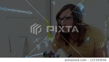 Mustard-clad man examining data overlays on monitor at home office, with pencils and sticky notes Mustard-clad man examining data overlays on monitor at home office, with pencils and sticky notes 135393646